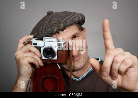 Photographer with an old retro camera, smiling. Studio shot Stock Photo