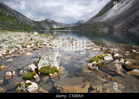 Mountain lake with stones in transparent water. Eastern Sayan mountains. Siberia. Buryat republic. Russia. Stock Photo