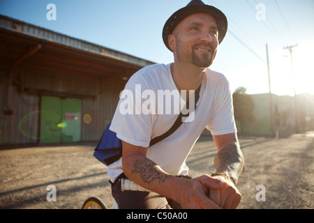 Bicycle messenger stopping on city street Stock Photo