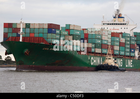 CSCL Oingdao Container Ship being assisted by tugboats up the Yarra River to Swanson Docks Melbourne Australia Stock Photo