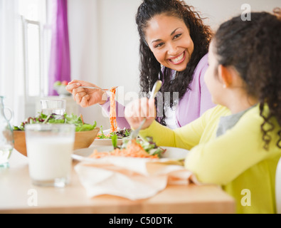 Mother and daughter eating dinner together Stock Photo