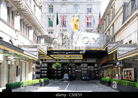 Savoy Hotel sign flags & statue above Savoy Court entrance to this London street West End luxury hotel England UK free of taxis because Strand closed Stock Photo