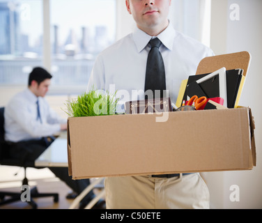 Fired Caucasian businessman carrying personal belongings Stock Photo