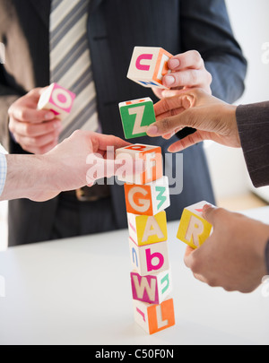 Business people stacking alphabet blocks Stock Photo