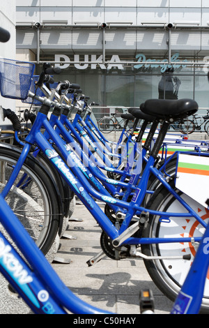 Row of blue bicycles for hire in front of 'Galeria Krakowska' -a huge shopping mall in Krakow downtown, Poland. Stock Photo