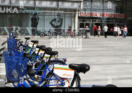 Row of blue bicycles for hire in front of 'Galeria Krakowska' -a huge shopping mall in Krakow downtown, Poland. Stock Photo