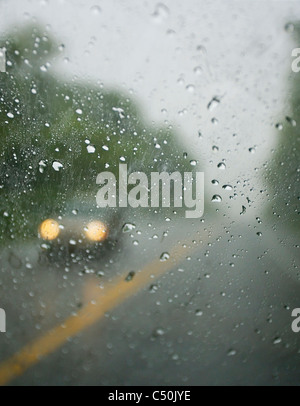 a car driving in the rain with headlights on as seen from inside another car. Stock Photo