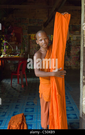 Novice Buddhist monk folding his robes, Wat Lolei, near Siem Reap, Cambodia Stock Photo