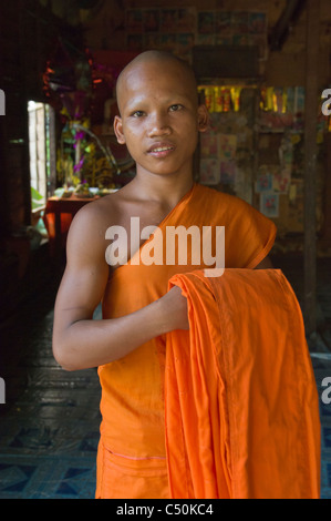 Novice Buddhist monk folding his robes, Wat Lolei, near Siem Reap, Cambodia Stock Photo