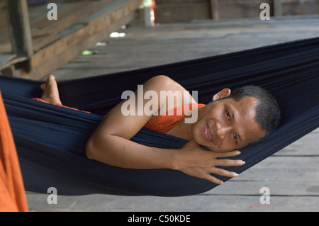 Novice Buddhist monk in a hammock, Wat Lolei, near Siem Reap, Cambodia Stock Photo