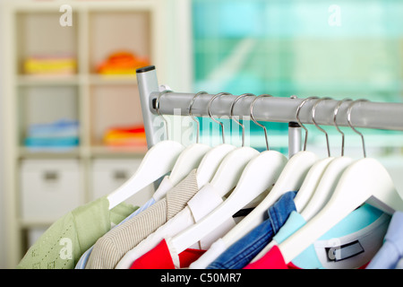 Photo of hangers with different clothes in department Stock Photo