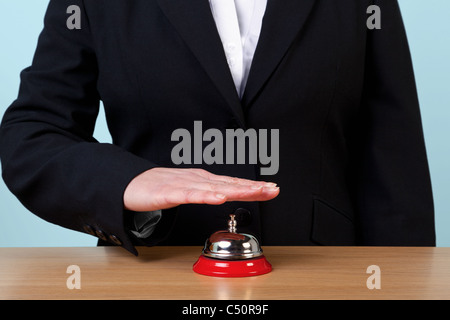 Photo of a woman ringing a reception service bell. Stock Photo