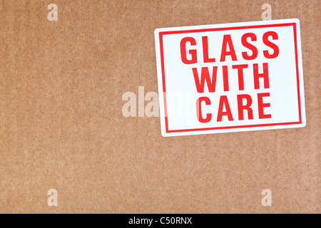 Photo of a Glass with care sticker on a cardboard background. Stock Photo