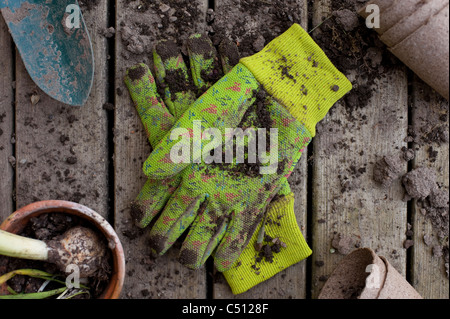Gardening tools with flower pots and gardening tools on a back deck with work gloves Stock Photo