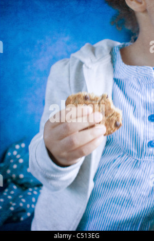 Little girl holding cookie, mid-section Stock Photo