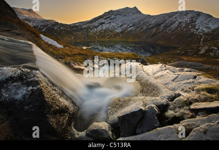 A small creek running through Skittendalen Valley in Troms County, Norway. Rismålstinden Mountain is in the background. Stock Photo