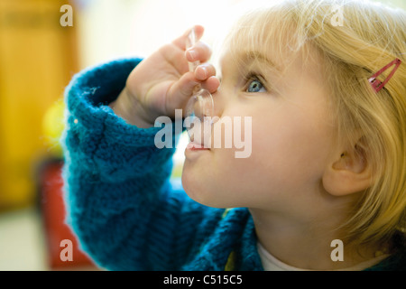 Baby girl feeding herself with spoon Stock Photo