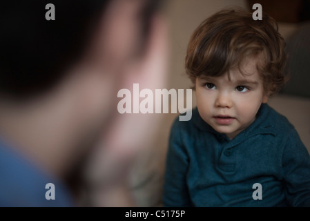 Toddler playing peek-a-boo with father Stock Photo