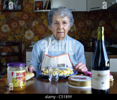 Senior woman eating at table, portrait