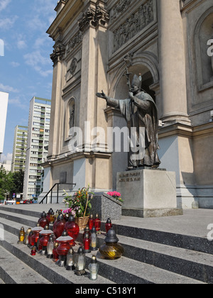 Votive candles in front of a statue of Pope John Paul II. The All Saints Church, Warsaw, Poland. Stock Photo