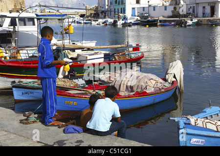 Africa, Tunisia, Bizerte, Old Port Canal, Fishing Boats in the Harbor, Boys Fishing Stock Photo