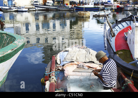 Africa, Tunisia, Bizerte, Old Port Canal, Harbor, Fisherman Mending Fishing Net Stock Photo