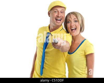 Laughing young couple with a TV remote control. Isolated on white background. Stock Photo