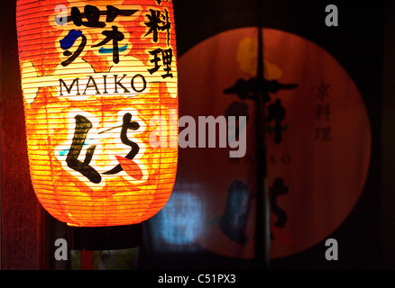 A red orange hanging lantern and curtain of a traditional Geisha restaurant in traditional Gion district, Kyoto, Japan JP Stock Photo