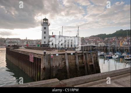 Scarborough Outer Harbour, calm sea, yachts & boats moored, lighthouse, evening sky & old town buildings) - scenic North Yorkshire Coast, England, UK. Stock Photo