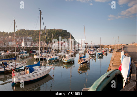 Scarborough Outer Harbour leisure craft moorings (yachts & boats moored in evening sun) & castle headland - scenic North Yorkshire Coast, England, UK Stock Photo