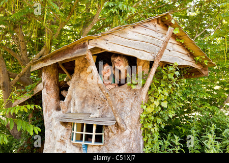 Two young women in beautiful traditional tree or Wendy house built by Clifford Matthews for his grandchildren. JMH5136