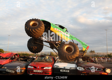 monster truck jumping over crushed cars in a race Stock Photo - Alamy