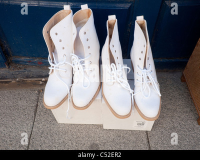 Two pairs of ladies boots high sided with canvas uppers and leather soles outside a bric a brac shop Stock Photo