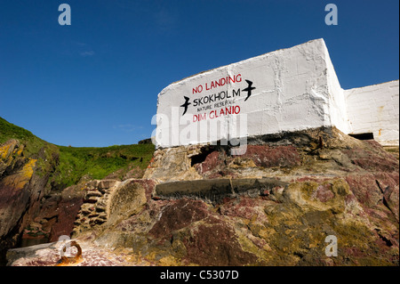 A white building against a clear blue sky overlooking the landing stage at Skokholm island Pembrokeshire South Wales UK Stock Photo