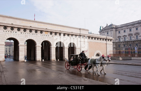 Horse driven carriage leaves the Hofburg Palace. Vienna, Austria. Stock Photo