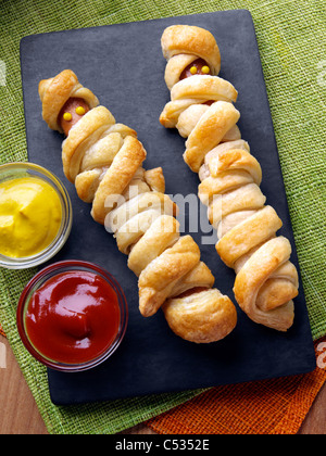 Wrapped frankfurter sausages with mustard and tomato ketchup Stock Photo