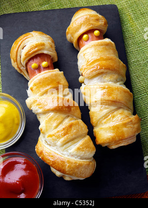 Wrapped frankfurter sausages with mustard and tomato ketchup Stock Photo