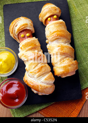 Wrapped frankfurter sausages with mustard and tomato ketchup Stock Photo