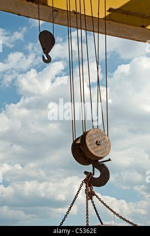Two lifting hooks on an old railroad crane with chains.Blue sky Stock Photo