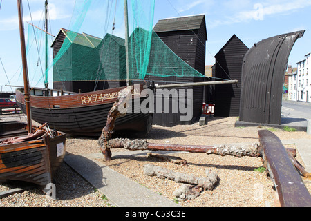 Hastings historic old fishing boats and net huts on the seafront on the Old Town stade beach East Sussex England UK GB Stock Photo