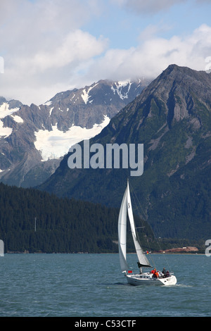 People sailing in Resurrection Bay near Seward with Kenai Mountains in the background, Southcentral Alaska, Summer Stock Photo