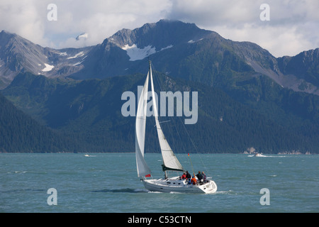 People sailing in Resurrection Bay near Seward with Kenai Mountains in the background, Southcentral Alaska, Summer Stock Photo