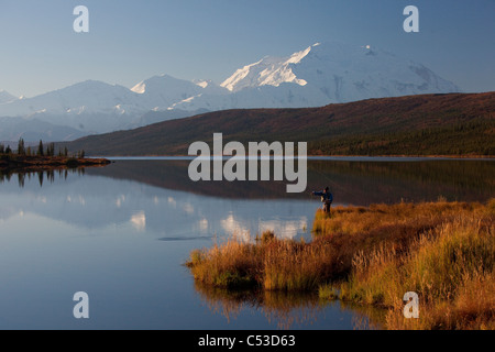 Fly fisherman casting over Wonder lake with Mt. McKinley in the background, Denali National Park and Preserve, Alaska Stock Photo