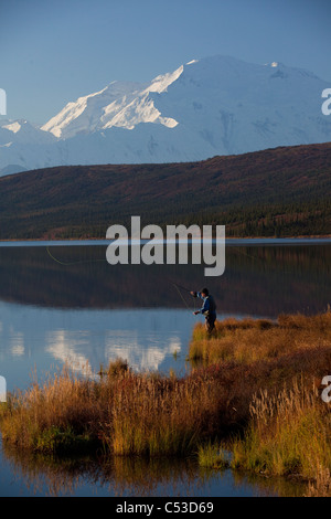 Fly fisherman casting over Wonder lake with Mt. McKinley in the background, Denali National Park and Preserve, Alaska