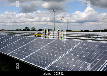 UKs first solar electric power station under construction at Fen Farm near Louth Lincolnshire and ecotricity wind farm behind Stock Photo