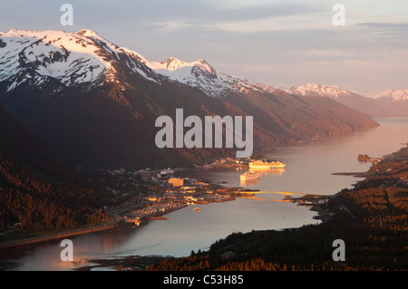 Aerial view of downtown Juneau and harbor at sunset with two cruise ships in port, Southeast Alaska, Summer Stock Photo