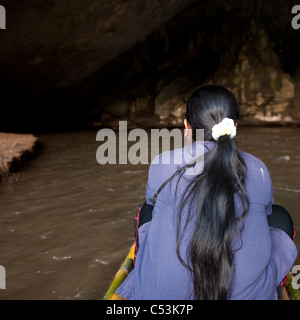 Rear view of a woman sitting on a bamboo boat, Thailand Stock Photo