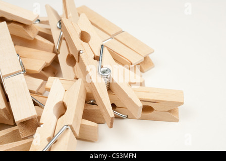 Many wooden clothes pegs isolated on white Stock Photo