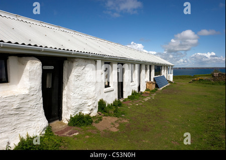 living accommodation on Skokholm island Pembrokeshire South Wales UK; Skomer island in the distance. Stock Photo