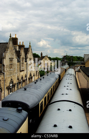 A view from the footbridge at Wansford station on the Nene Valley Railway, two lines of carriages disappearing into the distance Stock Photo